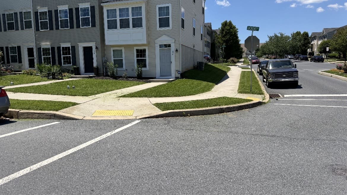 Corner lawn and curved sidewalk beside a residential building