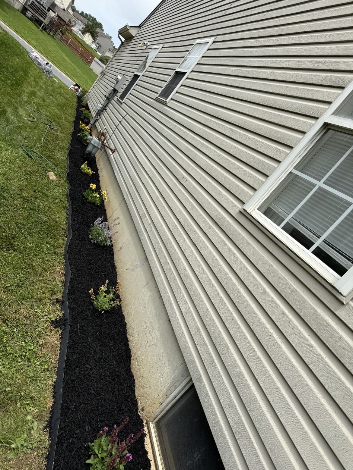 Narrow mulched bed along house siding