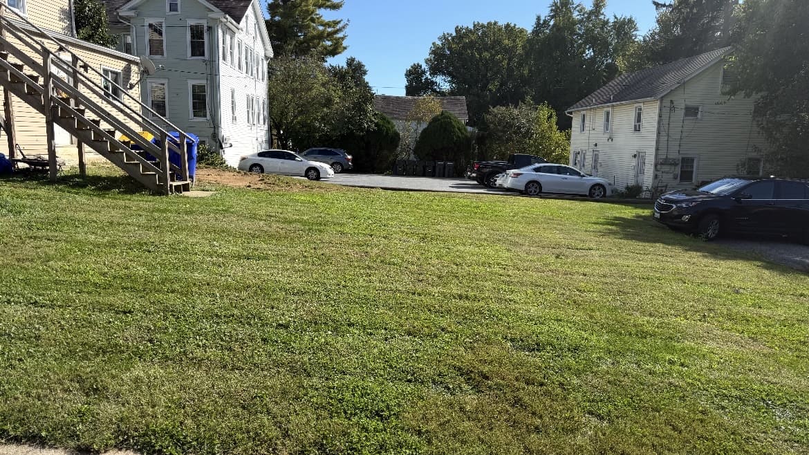 Lawn beside a house, outdoor stairs, and driveway