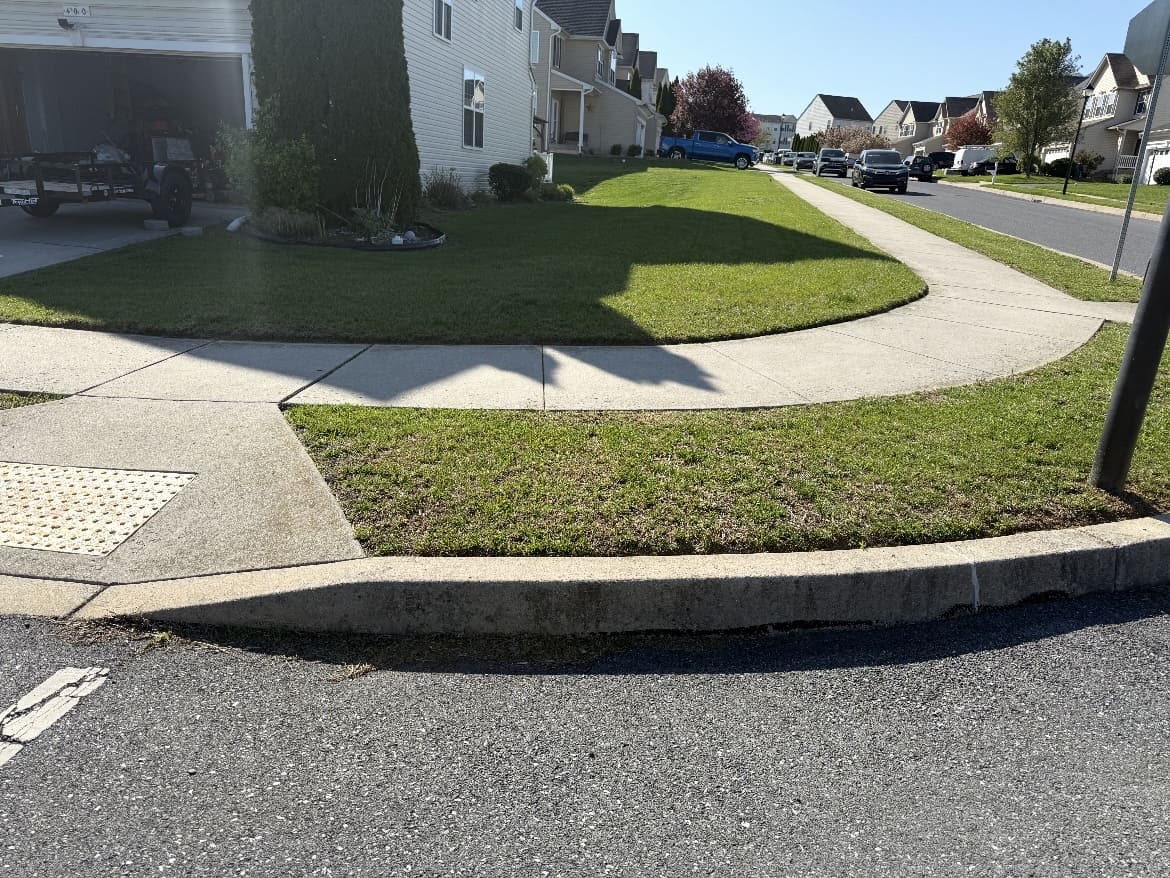 Defined lawn border along a curved sidewalk and curb